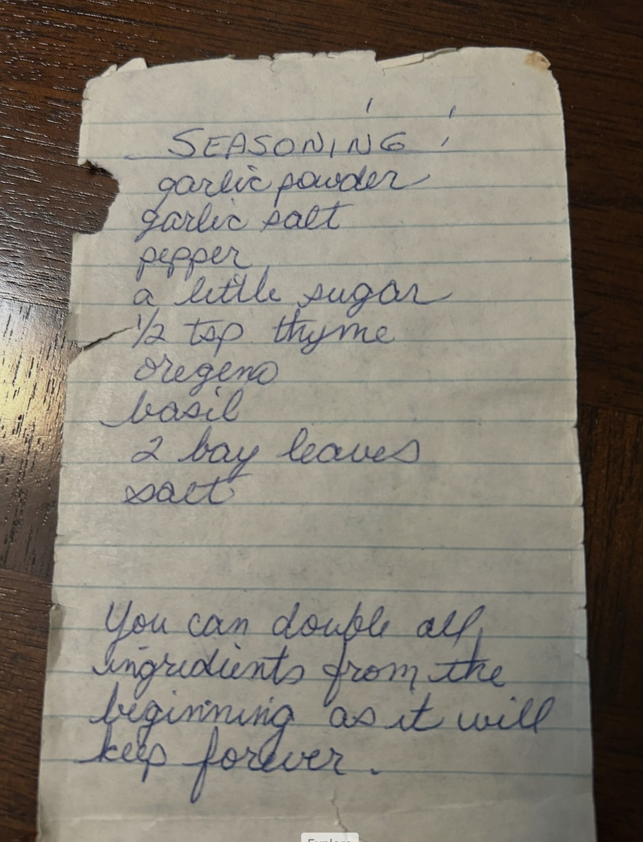 Back of a worn handwritten recipe card listing seasonings for spaghetti sauce
