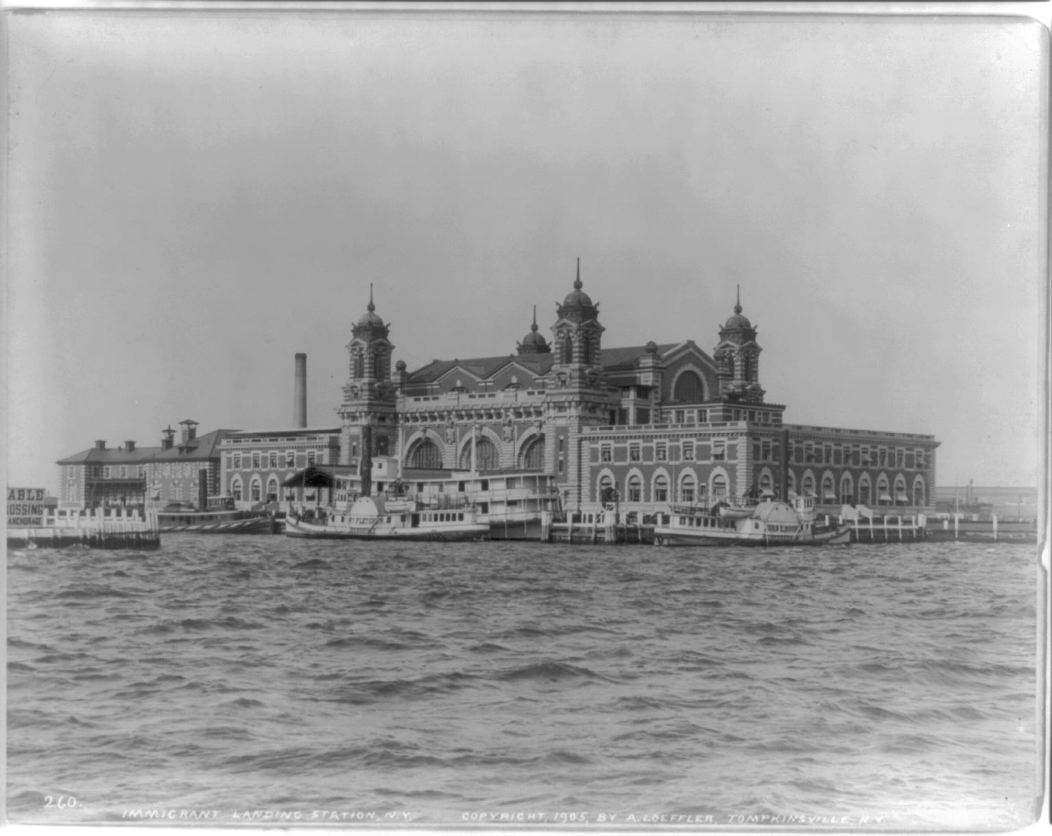 The Ellis Island immigration station seen across the water, with steamers alongside, in a photograph published in 1905